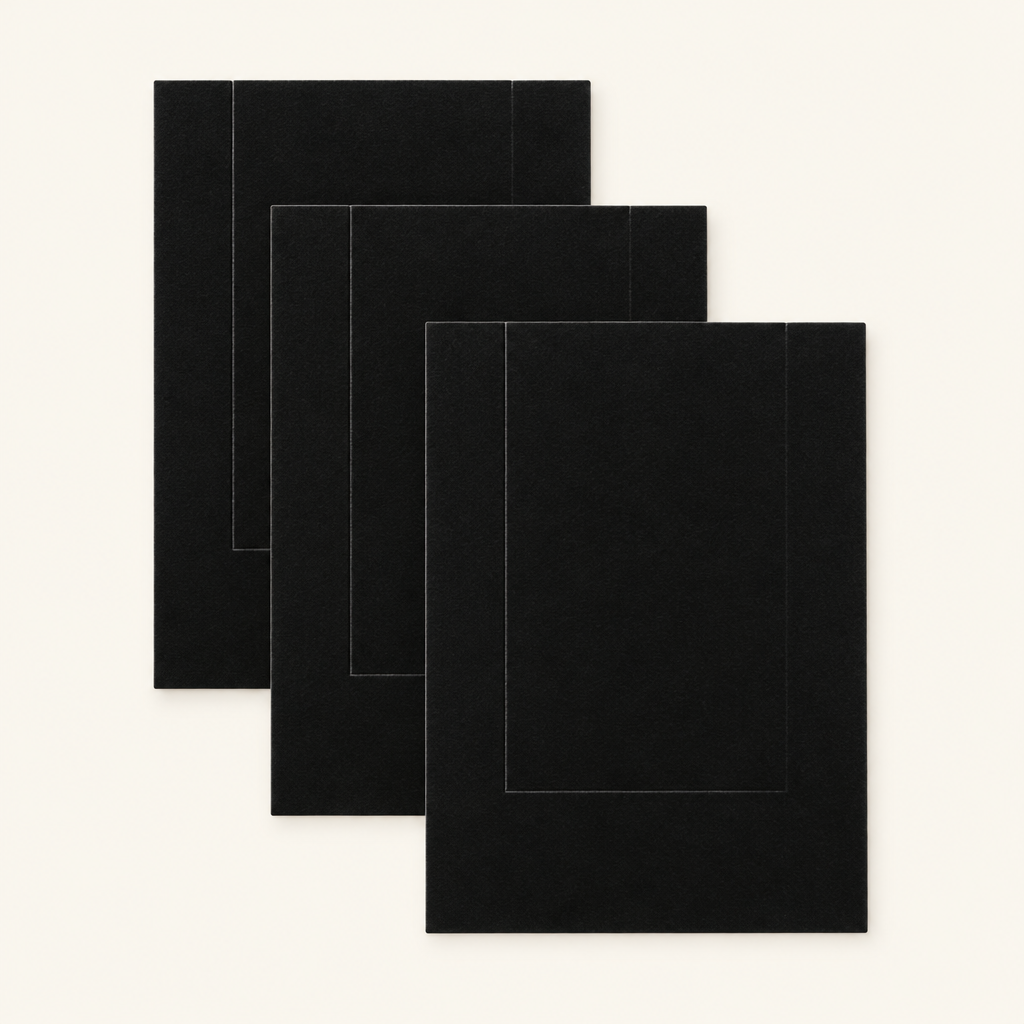 Three thin black replacement abrasive scratch sheets overlapping diagonally — surfaces only, board not included